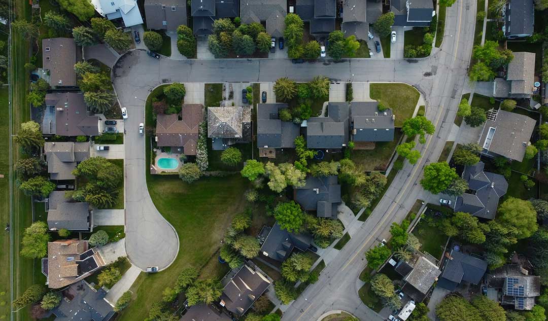 Aerial view of a suburban neighborhood featuring houses, streets, and green spaces.