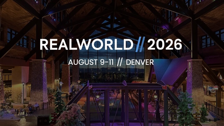 Interior view of a large, illuminated hall with wooden beams, promoting RealWorld 2026 event in Denver, August 9-11.